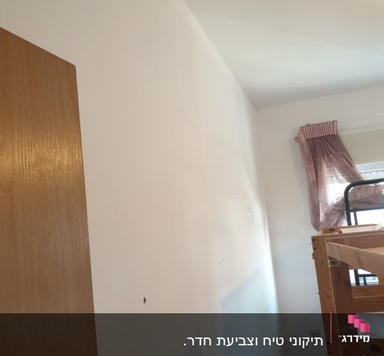 קיר צבוע בלבן עם חורים קטנים